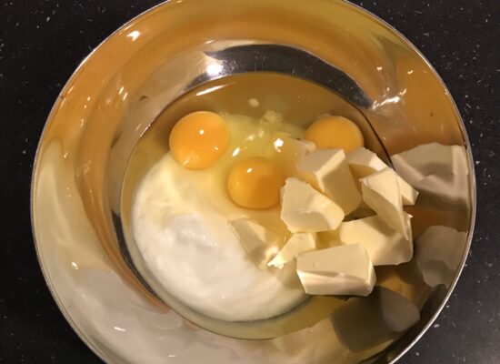 Mix de yoghurt, de boter en eieren tot alles gemengd is, voeg dan de bakmix toe en roer goed door.